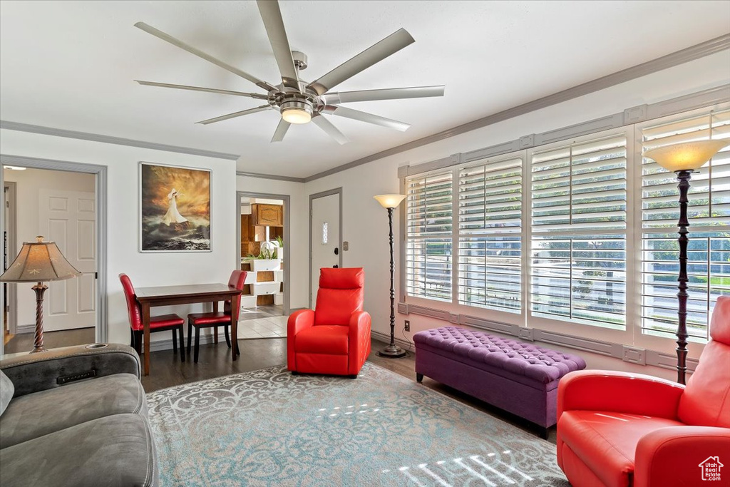 Living room with wood-type flooring, ceiling fan, and ornamental molding