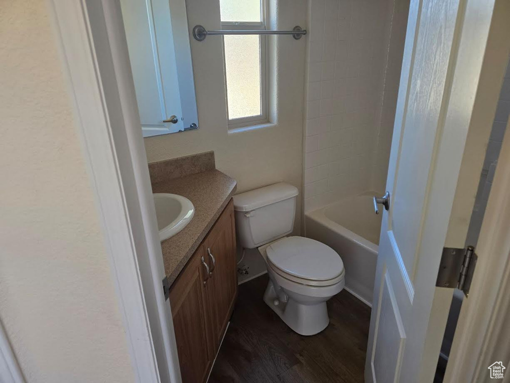 Bathroom featuring vanity, hardwood / wood-style flooring, and toilet