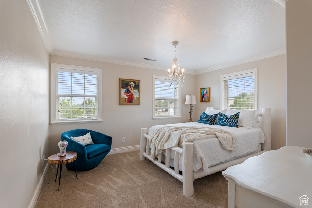 Carpeted bedroom with ornamental molding, multiple windows, and a chandelier