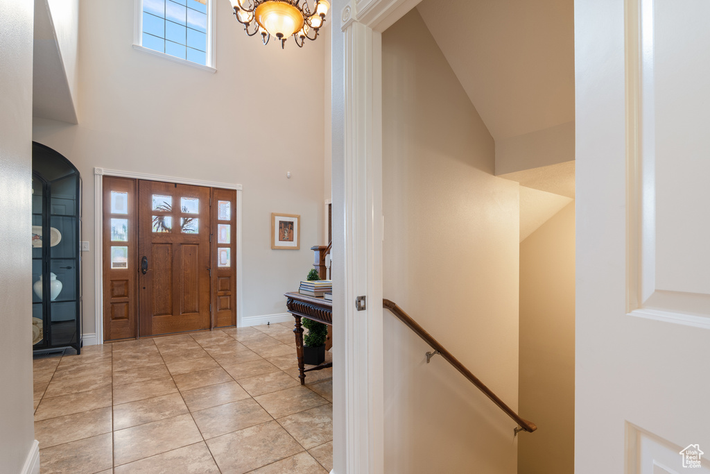 Foyer with a towering ceiling, a chandelier, and arched walkways