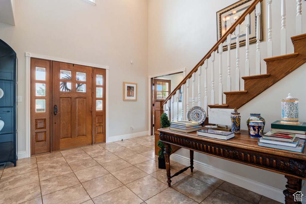 Entrance foyer with stairs, a towering ceiling, and arched walkways