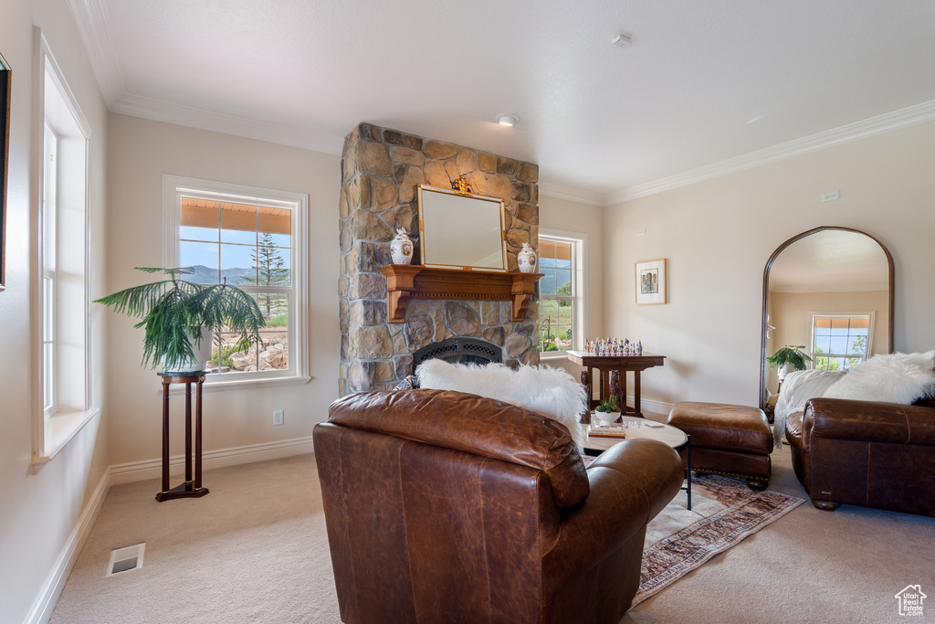 Living room with light carpet, a stone fireplace, and crown molding