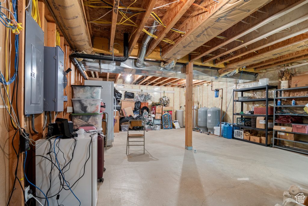 Unfinished basement with a water pressure tank and a water softener system