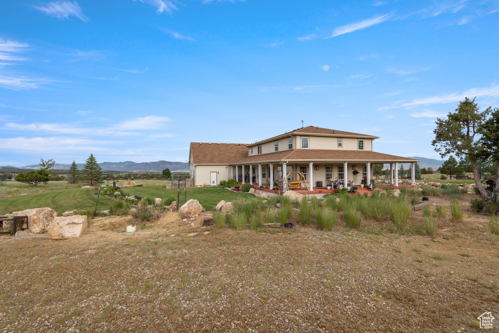 Rear view of house featuring a porch and a mountain view