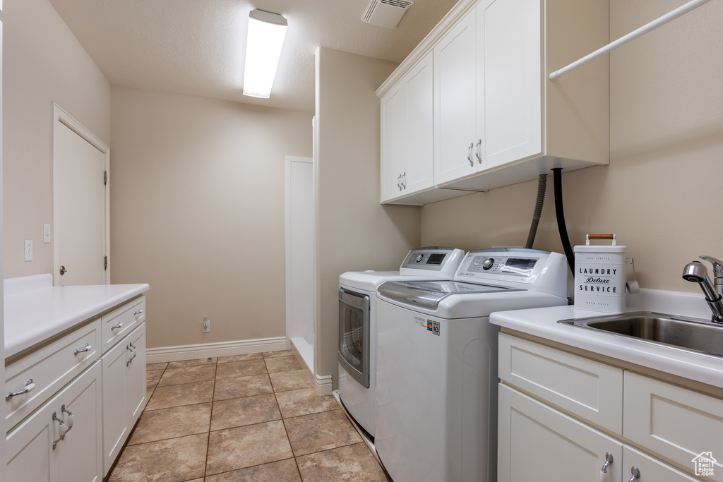 Laundry area featuring cabinet space and separate washer and dryer
