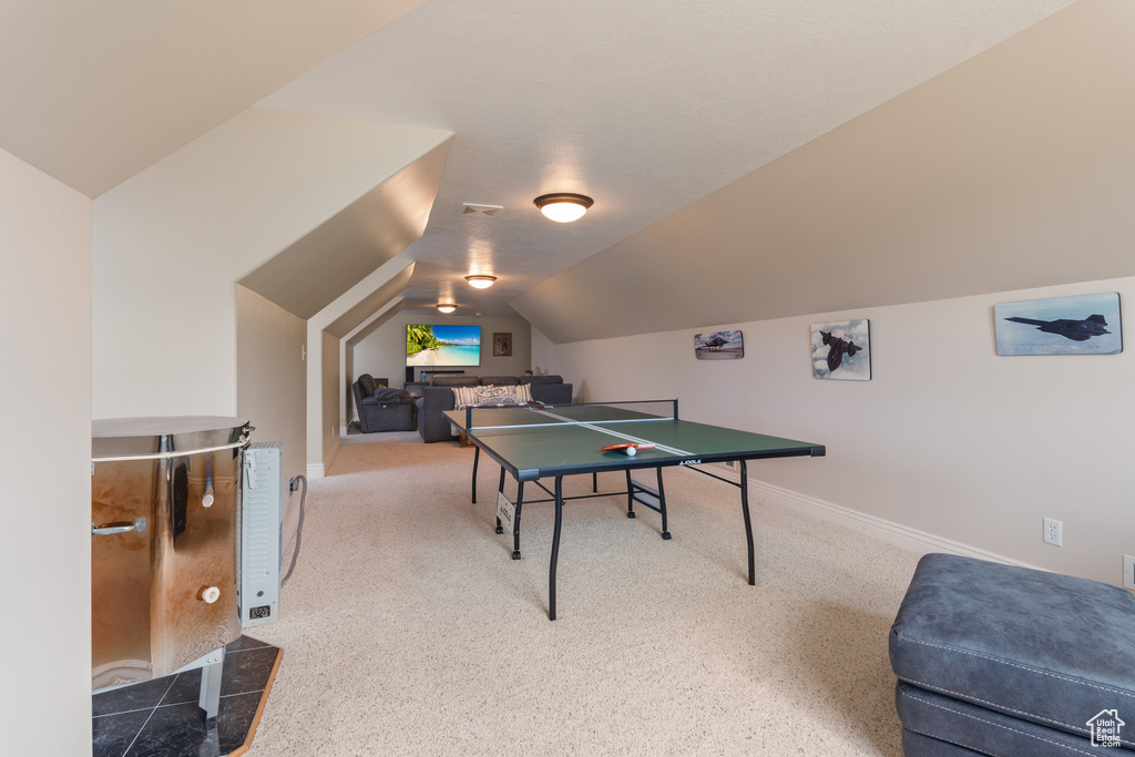Recreation room featuring vaulted ceiling and carpet