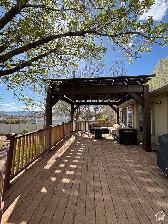 Wooden terrace featuring an outdoor hangout area, a pergola, and fence