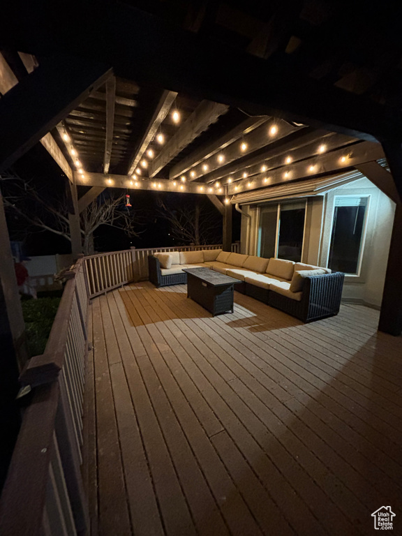 Deck at night featuring outdoor lounge area