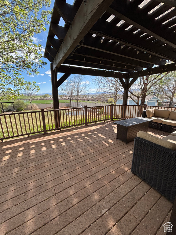 Wooden deck with a pergola, an outdoor living space, and fence