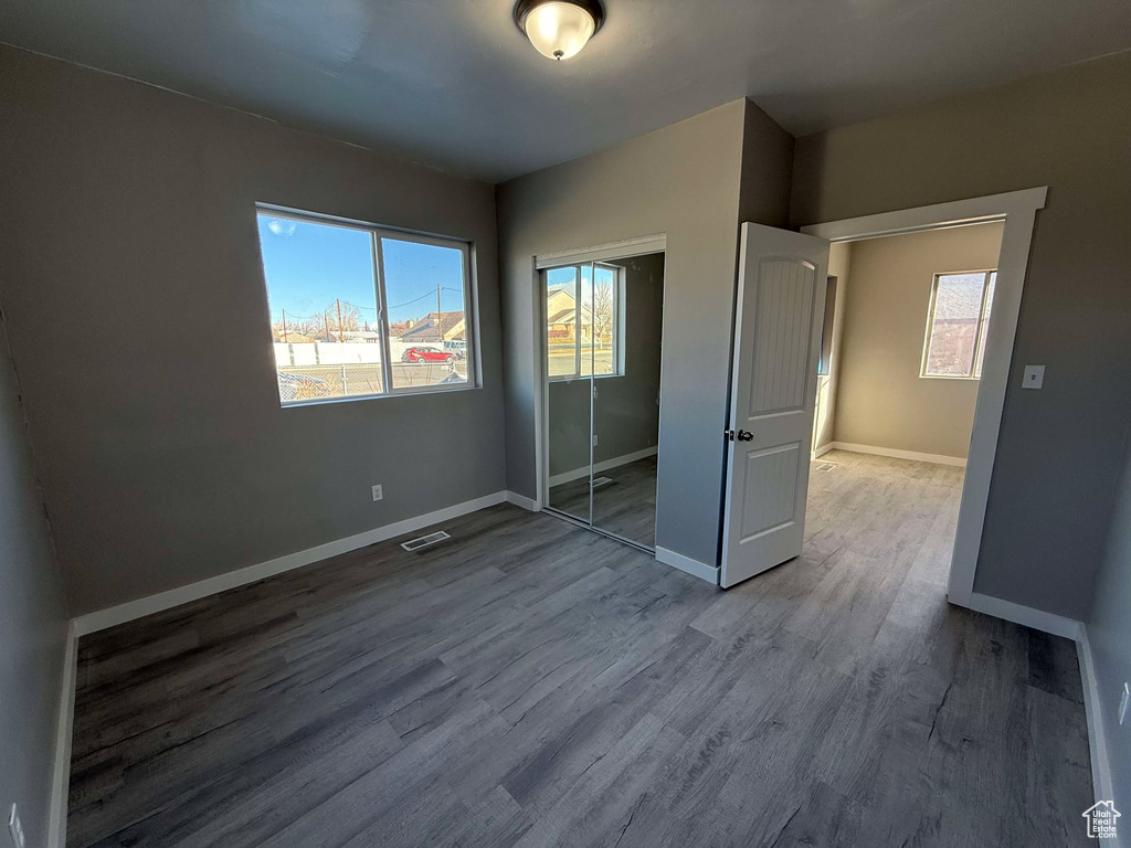 Unfurnished bedroom featuring wood-type flooring and a closet