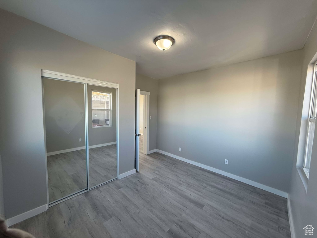 Unfurnished bedroom with hardwood / wood-style floors and a closet