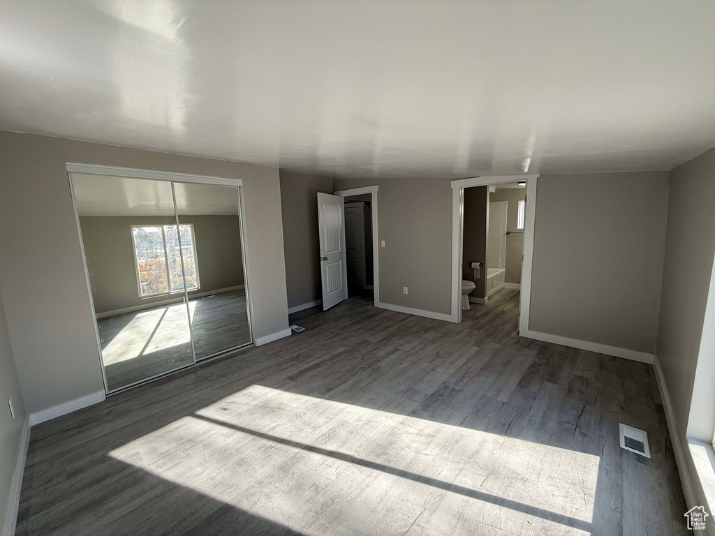 Spare room featuring dark wood-type flooring