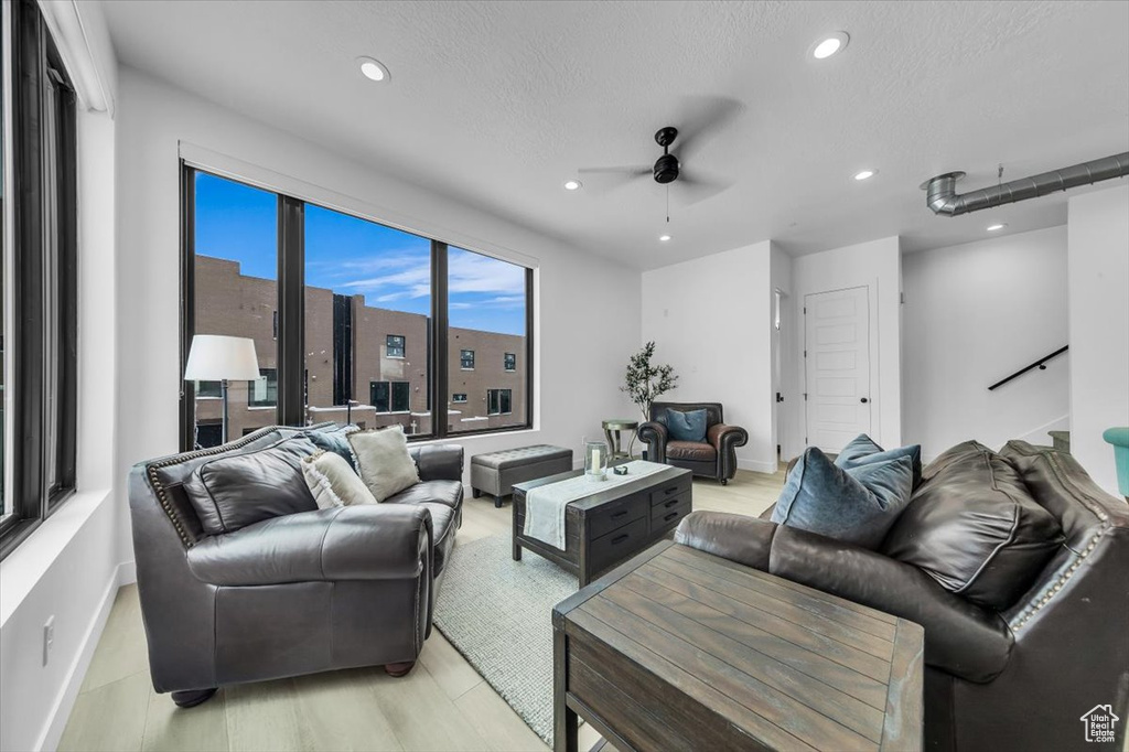 Living room with a textured ceiling, recessed lighting, baseboards, and ceiling fan