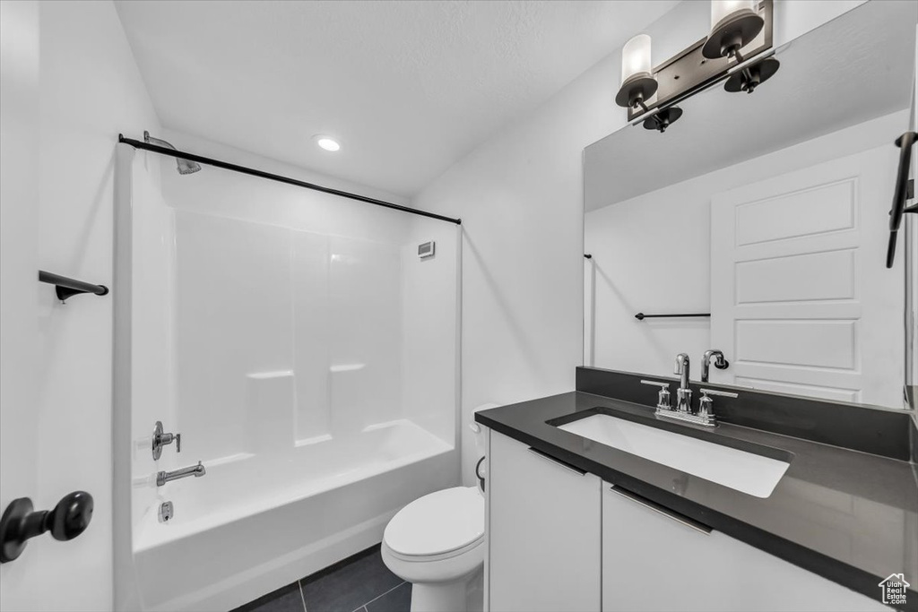 Full bathroom featuring tile patterned floors, toilet, vanity, and bathing tub / shower combination