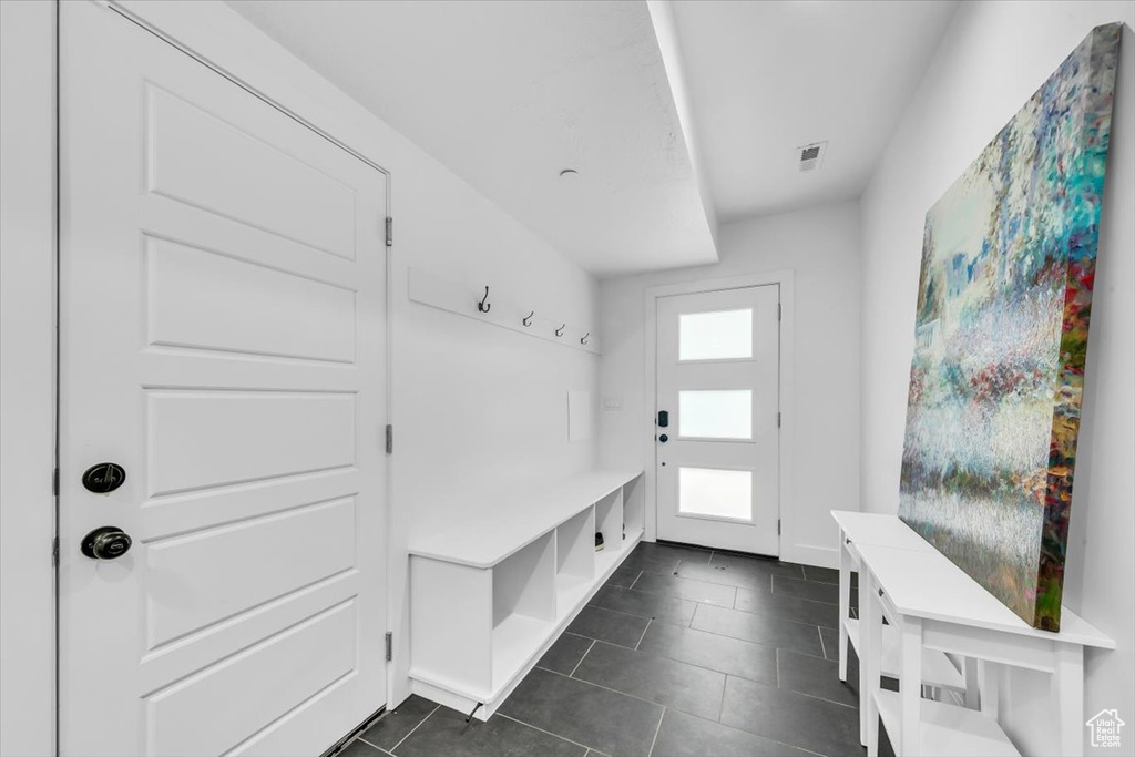 Mudroom with visible vents, baseboards, and dark tile patterned flooring