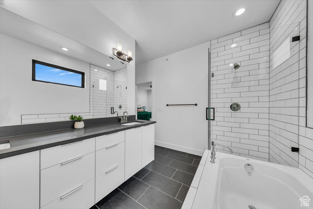 Bathroom with enclosed tub / shower combo, recessed lighting, tile patterned flooring, baseboards, and vanity