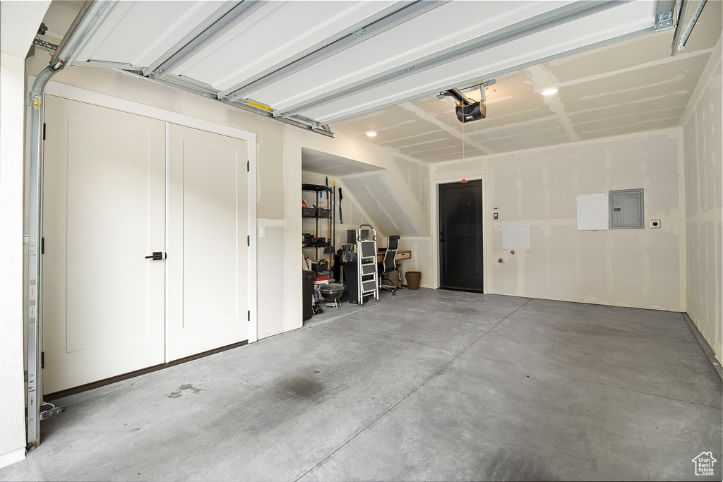 Garage featuring electric panel and a garage door opener