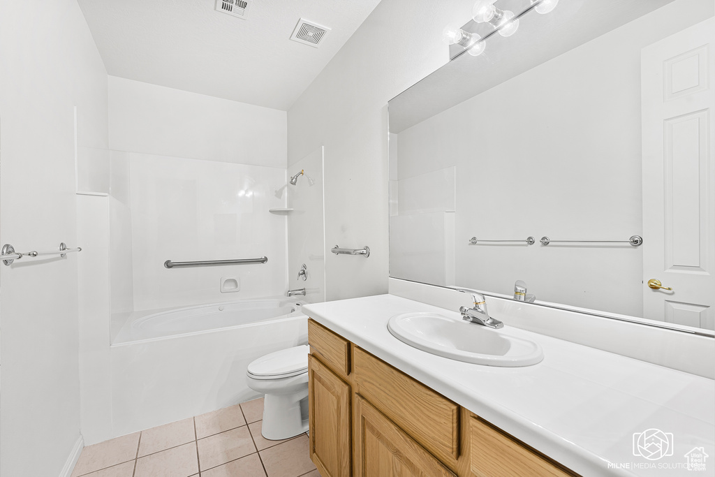Full bathroom with toilet, vanity, tile patterned floors, and tub / shower combination
