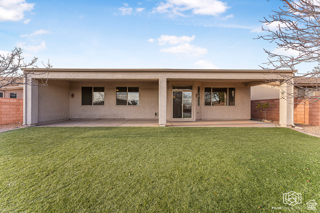 Rear view of house with a patio area and a yard