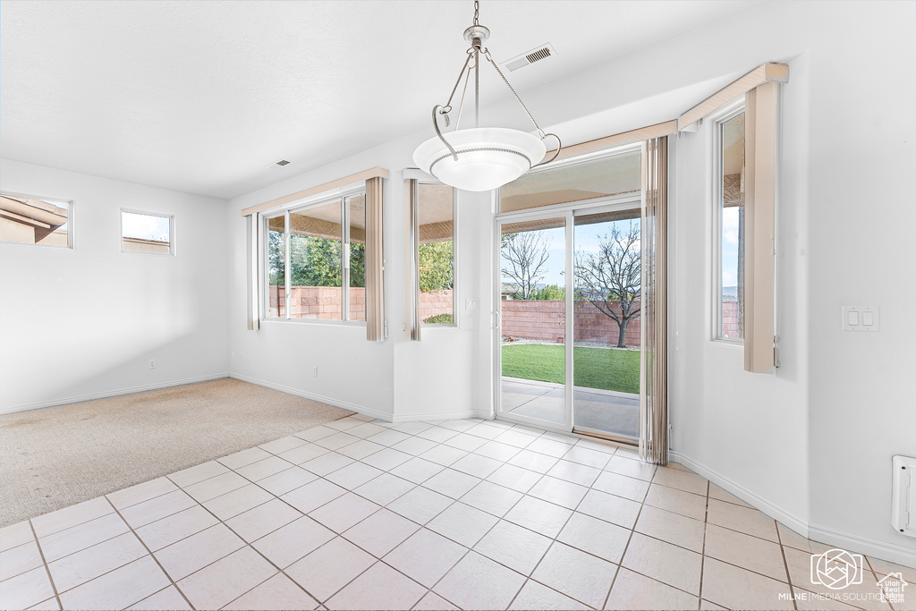 Unfurnished dining area featuring light colored carpet
