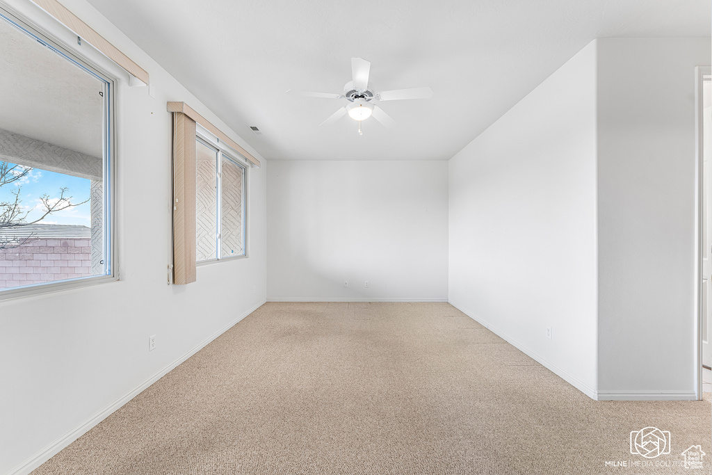 Carpeted spare room with ceiling fan