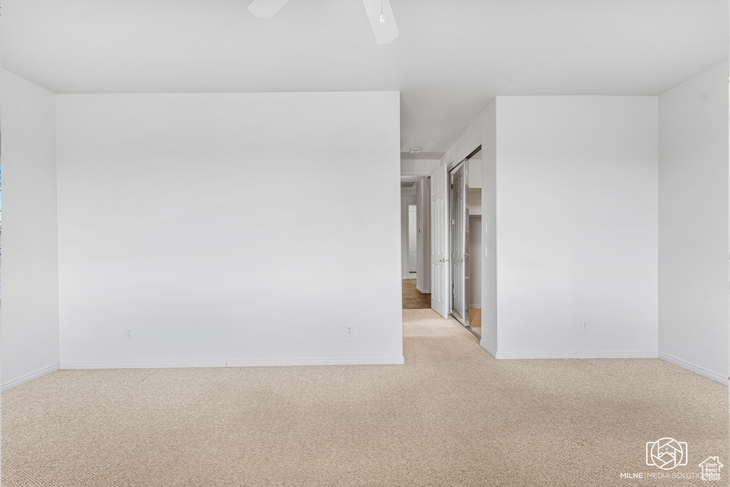 Empty room with light carpet and ceiling fan
