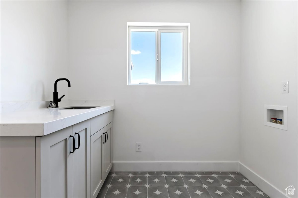 Laundry area featuring cabinets, washer hookup, and sink