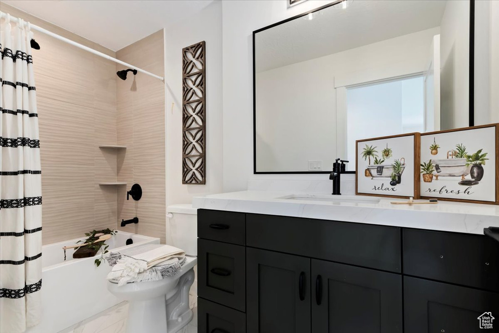 Full bathroom featuring shower / bath combo with shower curtain, vanity, and toilet
