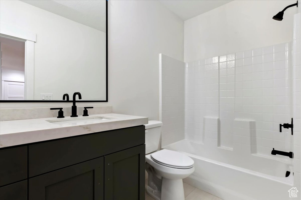 Full bathroom featuring shower / tub combination, vanity, toilet, and tile patterned floors