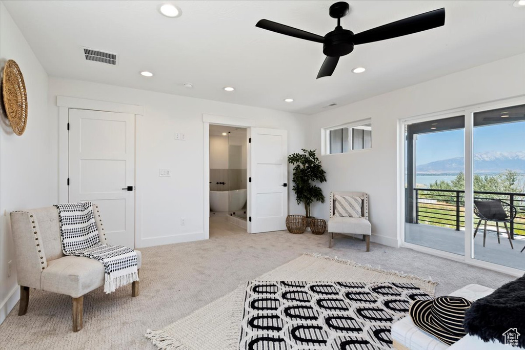 Living area with light colored carpet and ceiling fan