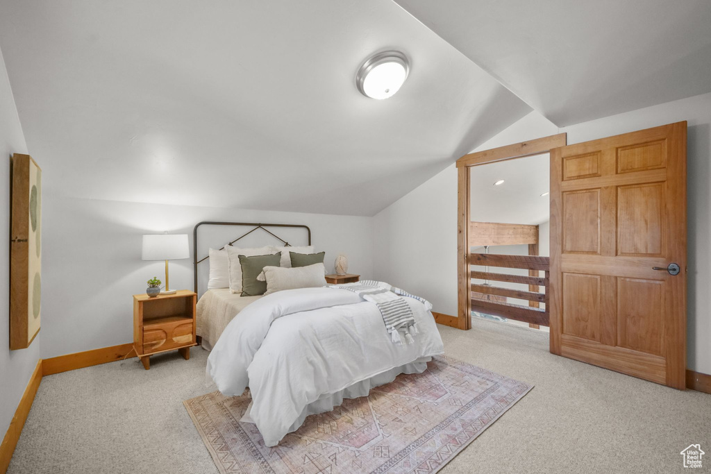 Carpeted bedroom with lofted ceiling