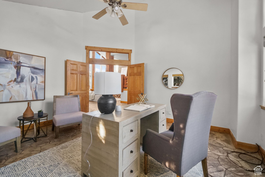 Office area featuring ceiling fan and a high ceiling