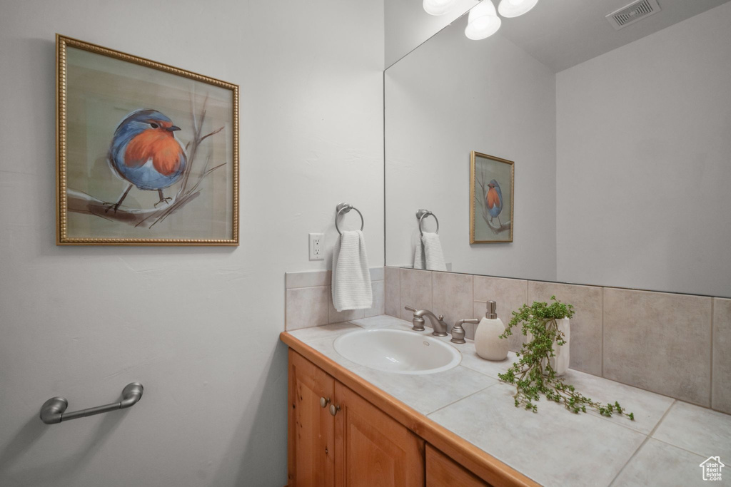 Bathroom with tasteful backsplash and vanity