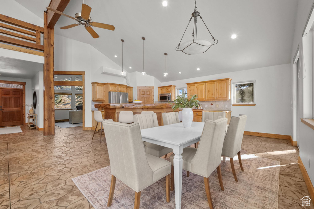 Dining area featuring ceiling fan and high vaulted ceiling