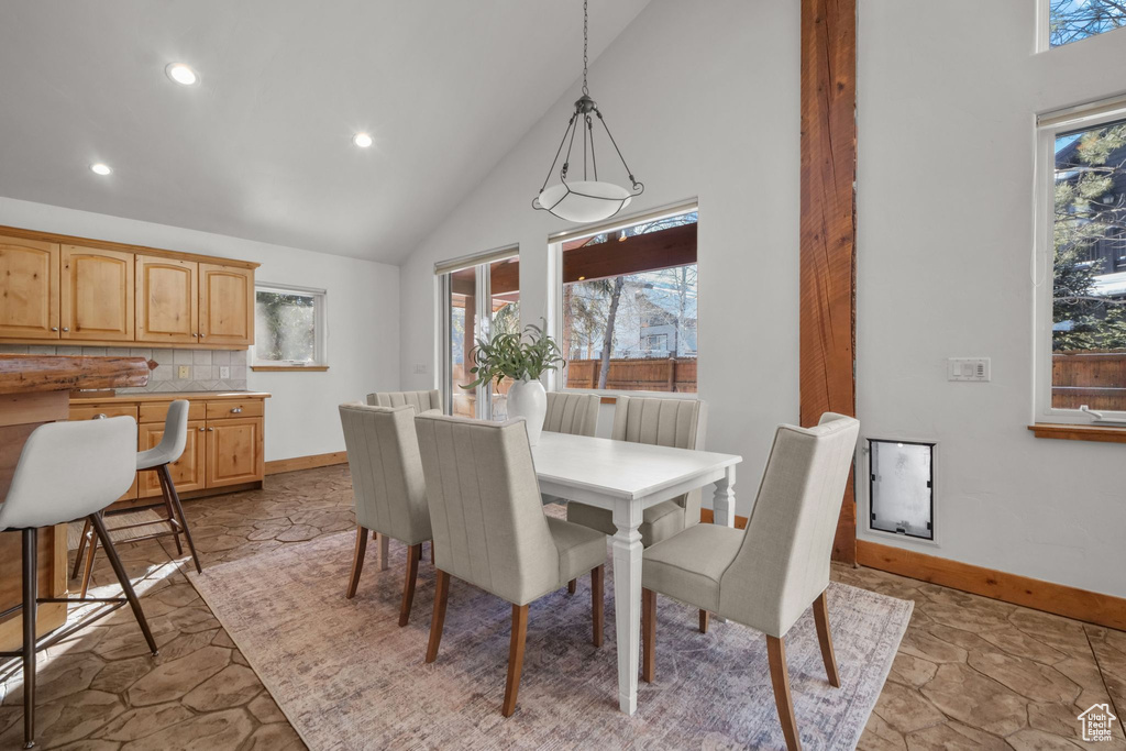 Dining area featuring high vaulted ceiling and plenty of natural light