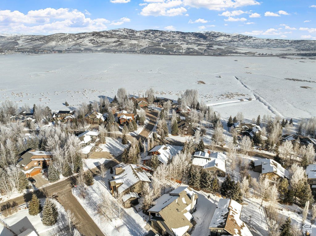 Snowy aerial view with a water and mountain view