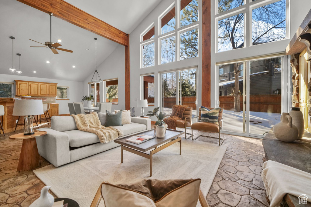 Living room featuring ceiling fan, a high ceiling, and beam ceiling