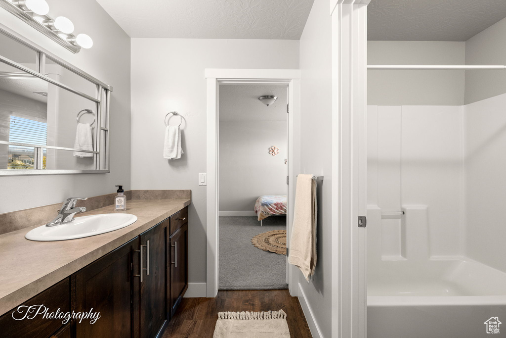 Bathroom with vanity, wood-type flooring, and a textured ceiling