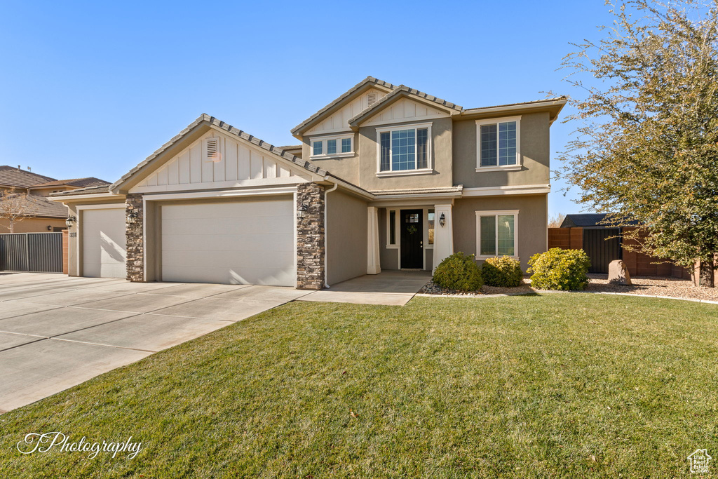 View of front of house featuring a front lawn and a garage