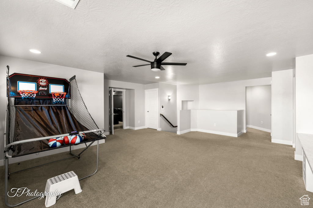 Rec room with carpet, ceiling fan, and a textured ceiling