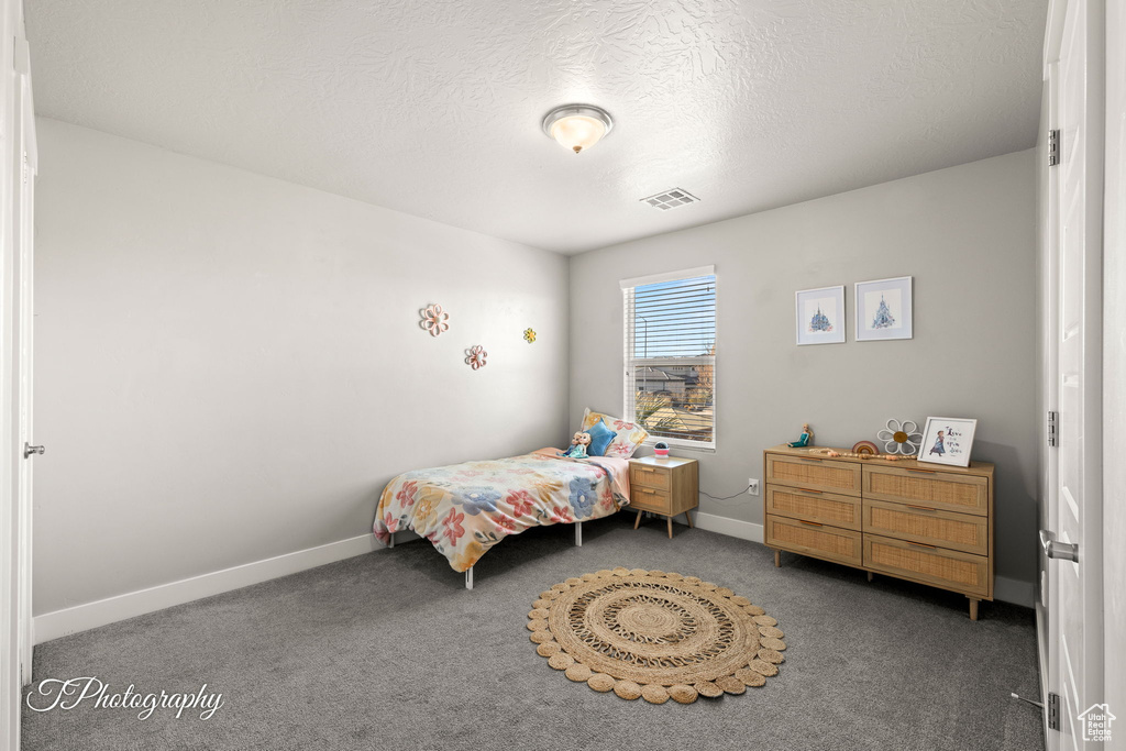 Carpeted bedroom with a textured ceiling