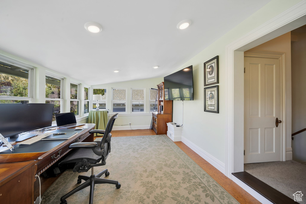 Home office featuring light wood-type flooring and vaulted ceiling