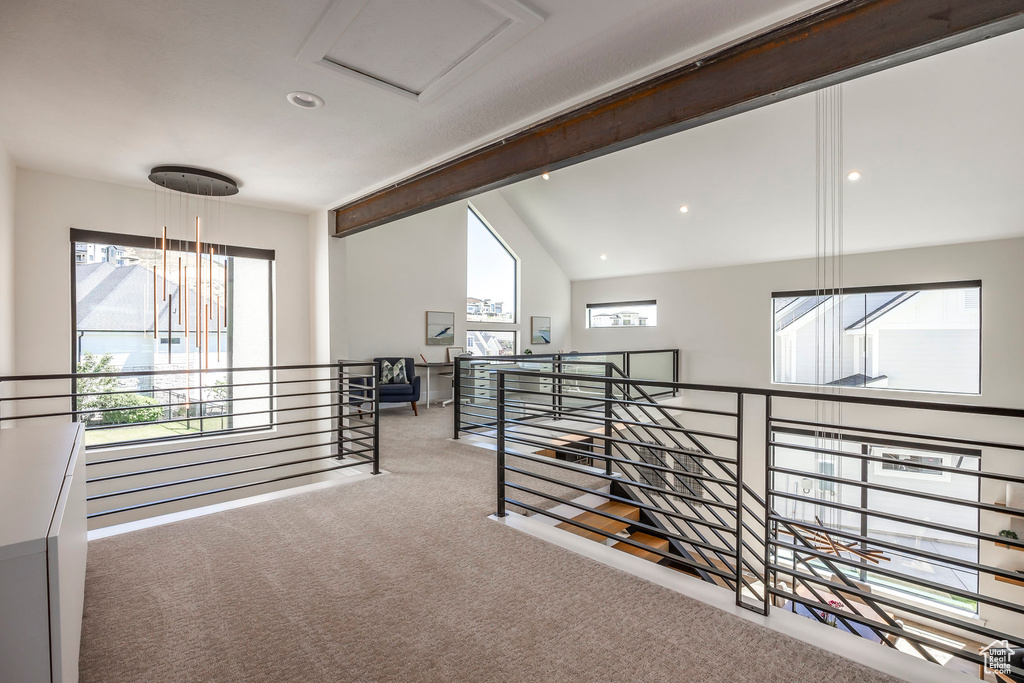 Hallway featuring carpet floors and lofted ceiling