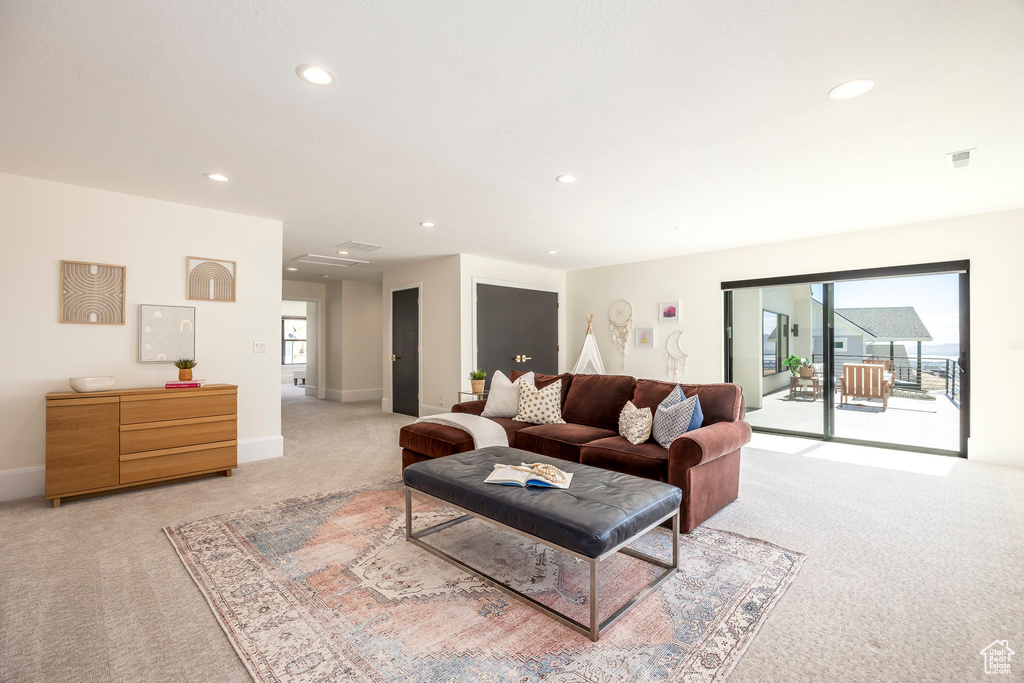 Living room with light colored carpet and plenty of natural light