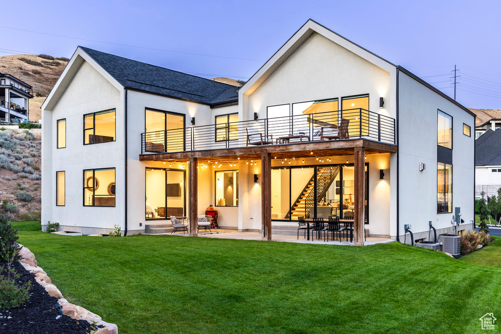 Back of house with a yard, a balcony, and a patio area