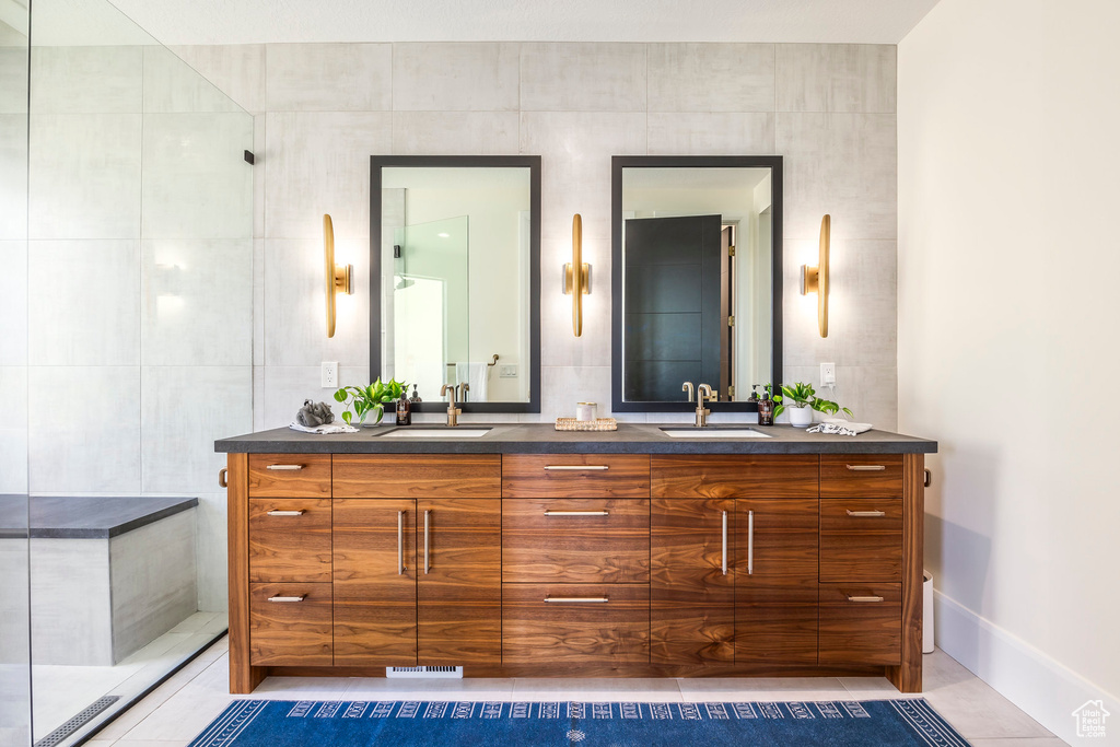 Bathroom featuring tile patterned flooring, vanity, and tile walls