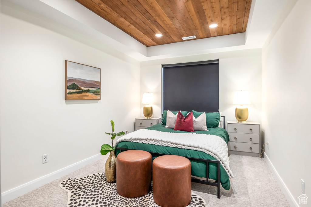 Bedroom featuring carpet flooring, a raised ceiling, and wooden ceiling