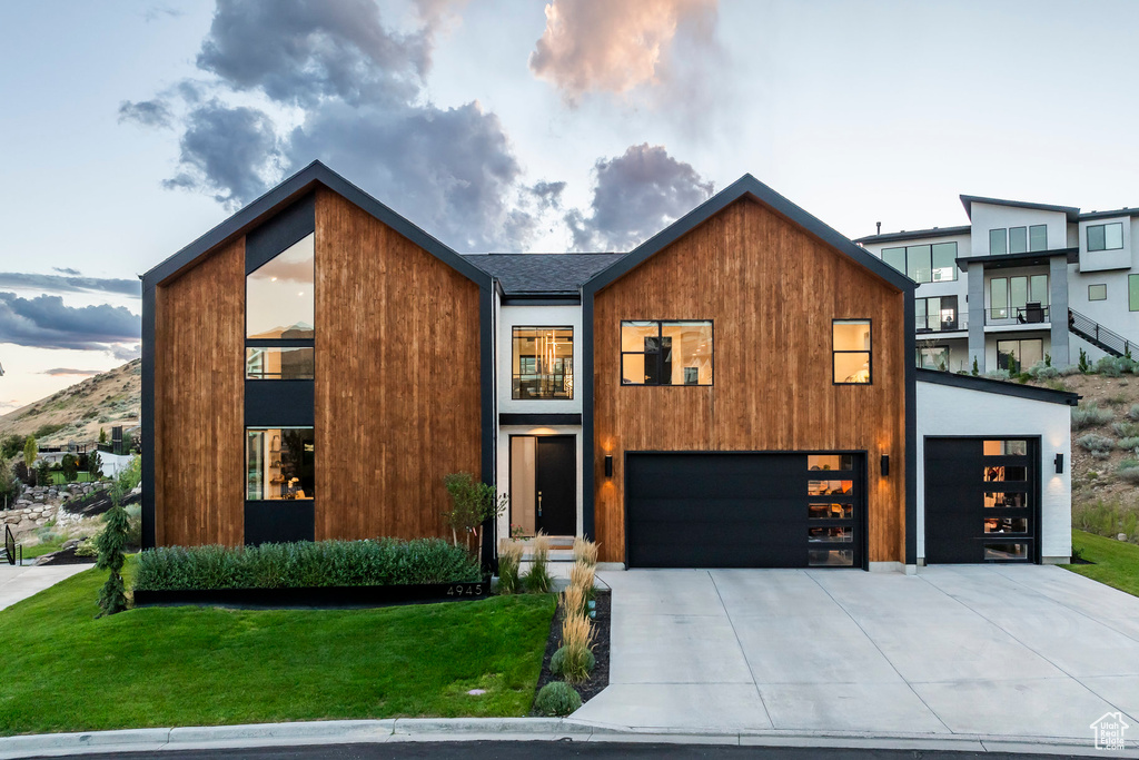 Contemporary house featuring a garage and a lawn