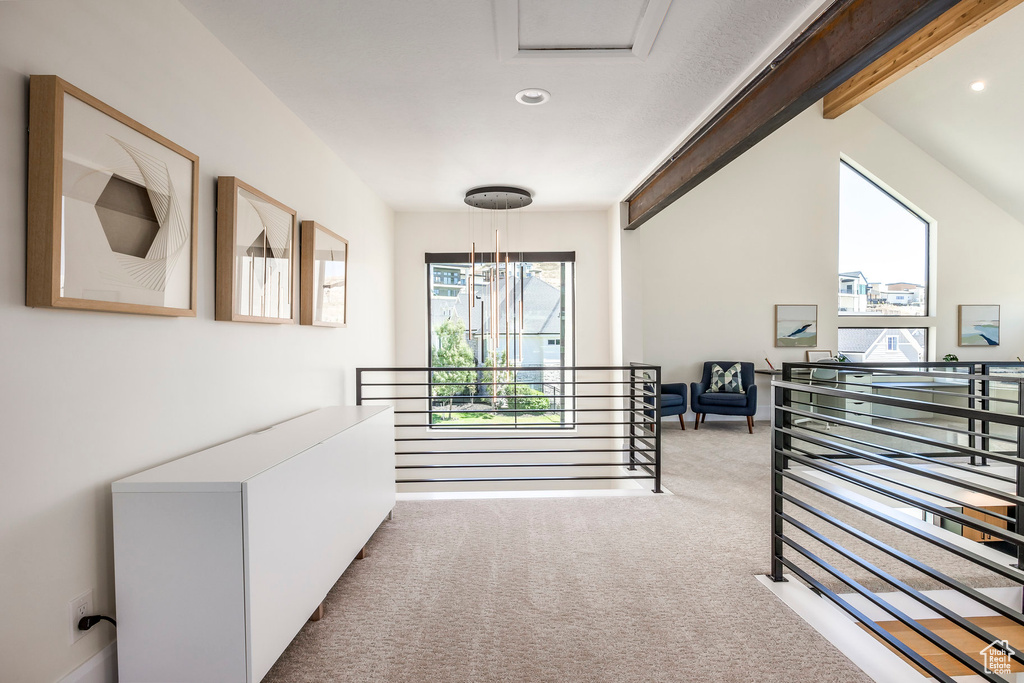 Hall with light carpet and lofted ceiling with beams