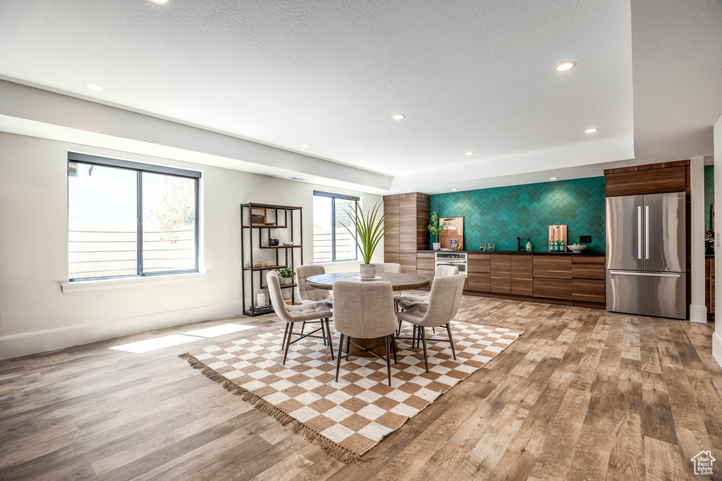 Dining room with light hardwood / wood-style flooring and a healthy amount of sunlight